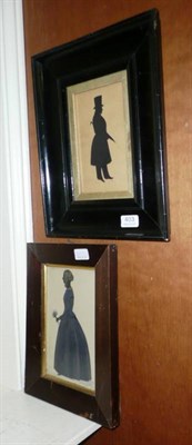 Lot 403 - A silhouette cutout standing portrait of a lady, circa 1840, her hair in a bun and ringlets,...