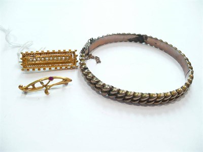 Lot 454 - A gold plated bangle and two yellow metal brooches