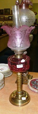 Lot 573 - Cranberry glass and brass column oil lamp