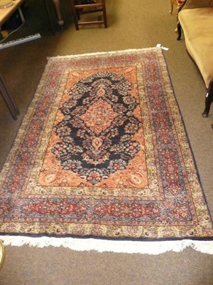 Lot 772 - Kashmir rug, North West India, the deep indigo field of flowering vines around a peach pole...