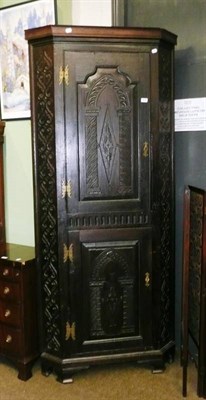 Lot 814 - A double carved oak corner cupboard