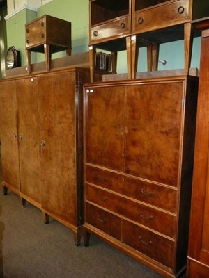 Lot 820 - A walnut bedroom suit comprising pair of single bed heads, triple wardrobe, tall boy, a pair of...