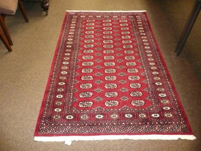 Lot 830 - A Bukara red ground fringed rug