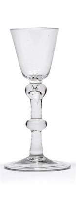 Lot 25 - A Wine Glass, circa 1750, the rounded funnel bowl on a stem with tiered knop at the shoulder...