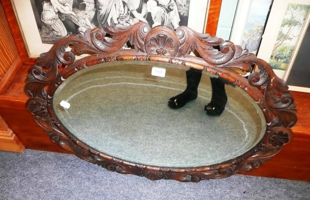 Lot 764 - A carved oak oval mirror