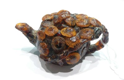 Lot 71 - A Chinese 'pressed amber' small wine pot carved in high relief with pine branches
