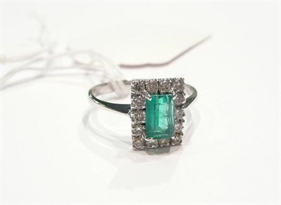 Lot 77 - A 14ct white gold emerald and diamond cluster ring