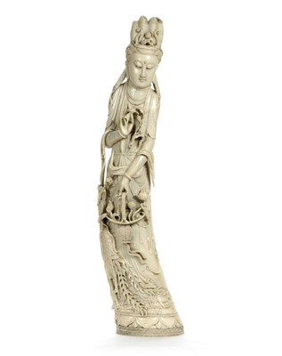 Lot 179 - A Chinese Carved Elephant Tusk Figure of Guanyin, circa 1930, the elegant goddess with...