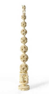 Lot 180 - A Chinese Export Carved Ivory Puzzle Ball Tower, circa 1970, surmounted by the figure of a standing