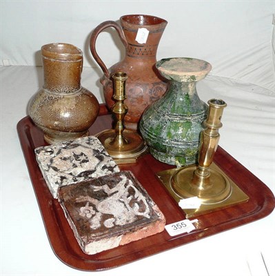 Lot 355 - Two early floor tiles, green glazed jug, two brass candlesticks etc