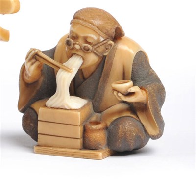 Lot 188 - A Japanese Carved and Stained Ivory Netsuke as a Noodle Eater, circa 1950-60, modelled as an...