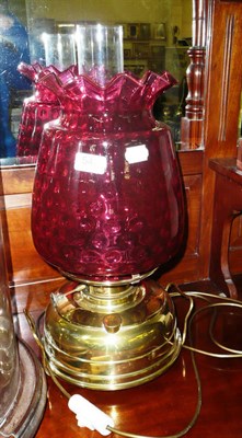 Lot 542 - Brass oil lamp with large cranberry glass shade