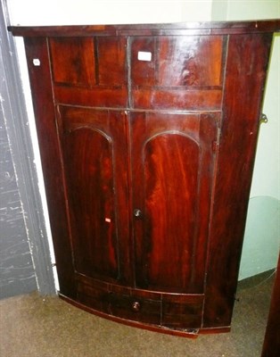 Lot 635 - A 19th century mahogany bow front hanging corner cabinet