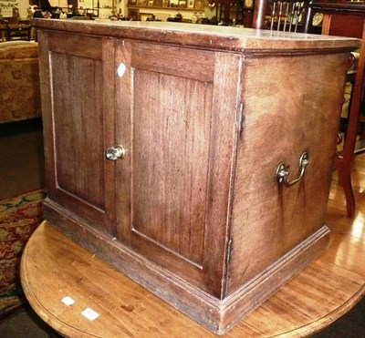 Lot 664 - An oak two door cupboard with carrying handles