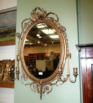 Lot 772 - 19th century gilt and gesso oval wall mirror with girandoles