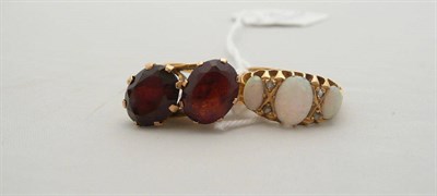 Lot 81 - An 18 carat gold opal and diamond ring and a garnet ring