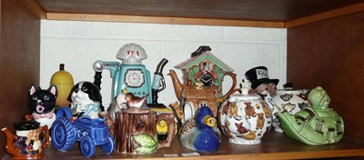 Lot 288 - Shelf of sixteen novelty teapots, a honey pot and a milk jug