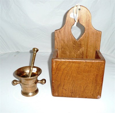 Lot 296 - An oak hanging candle box and a pestle and mortar