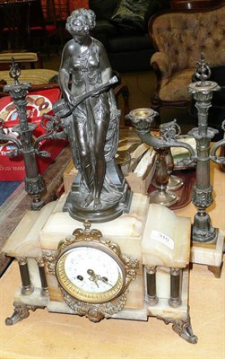 Lot 310 - An onyx and spelter striking mantel clock garniture