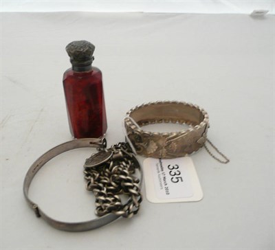 Lot 335 - Silver watch chain, silver sixpence, two silver bangles (86g) and a silver mounted scent bottle