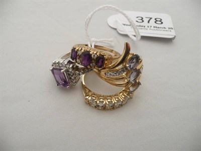 Lot 378 - A 9 carat gold amethyst three stone ring, a 9 carat iolite dress ring, a silver dress ring and...