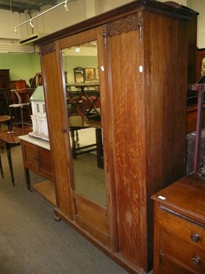 Lot 583 - An early 20th century oak three piece bedroom suite comprising mirror-door wardrobe, dressing chest