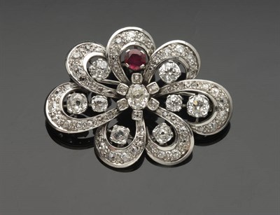 Lot 309 - A Diamond and Ruby Swirl Brooch, an oval cut diamond centres seven diamond set loops, four of which