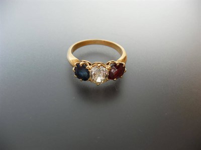 Lot 310 - A Sapphire, Diamond and Ruby Three Stone Ring, the stones held in yellow claw settings to a balloon