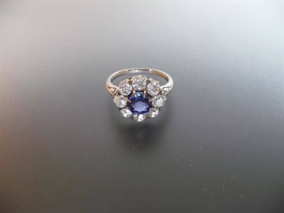 Lot 312 - An Edwardian Sapphire and Diamond Cluster Ring, the round cut sapphire bordered by old cut diamonds