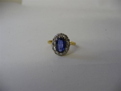 Lot 313 - A Sapphire and Diamond Cluster Ring, the oval cut sapphire bordered by round brilliant cut diamonds