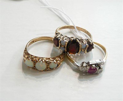 Lot 25 - A ruby and diamond ring, an opal ring and a garnet and opal ring (3)