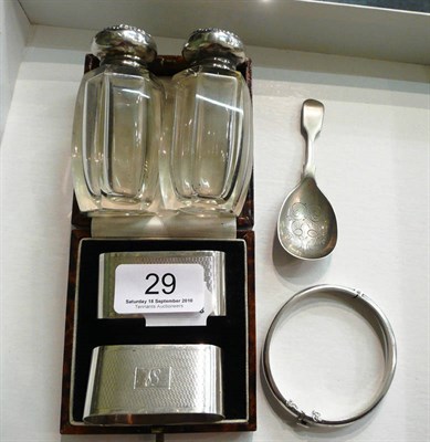 Lot 29 - Pair of silver napkin rings, silver bangle and a pair of silver-topped bottles
