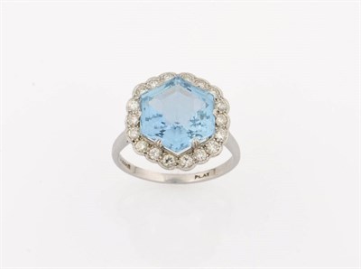 Lot 330 - An Aquamarine and Diamond Cluster Ring, a hexagon shaped step cut claw set aquamarine bordered...