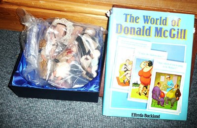 Lot 172 - Fifteen small dolls and an album of comic postcards 'World of Donald McGill' book