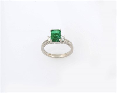 Lot 347 - A Platinum Emerald and Diamond Ring, the emerald-cut emerald is flanked by a baguette cut...