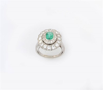 Lot 348 - An Emerald and Diamond Cluster Ring, the step cut emerald bordered by two rows of round...