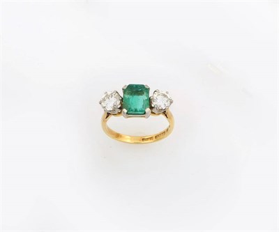 Lot 350 - An Emerald and Diamond Three Stone Ring, an emerald-cut emerald sits between two round...