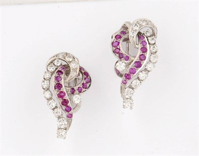 Lot 360 - A Pair of 18 Carat White Gold Ruby and Diamond Swirl Earrings, the round cut rubies and round...