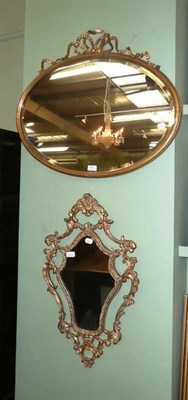 Lot 410 - A gilt and gesso oval wall mirror and a reproduction cartouche shaped mirror