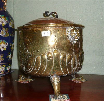 Lot 415 - A copper and brass log bin with lion paw handles and paw feet