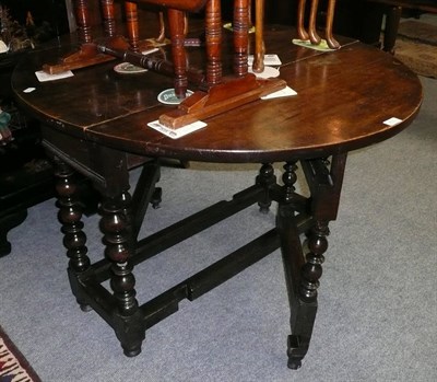 Lot 433 - A late 17th/18th century oak gateleg table, with double rounded fall flaps, on bobbin and ring...