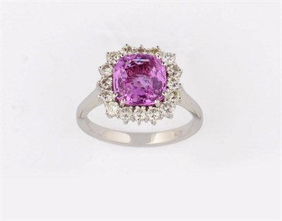 Lot 365 - An 18 Carat White Gold Pink Sapphire and Diamond Cluster Ring, the mixed cushion cut pink...