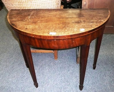 Lot 483 - A George III mahogany fold over tea table, the cross banded top on square tapering supports and...