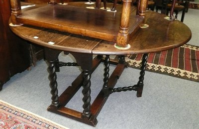 Lot 525 - An oak gateleg table, with broad oval surface and two fall flaps, on cable turned supports, moulded