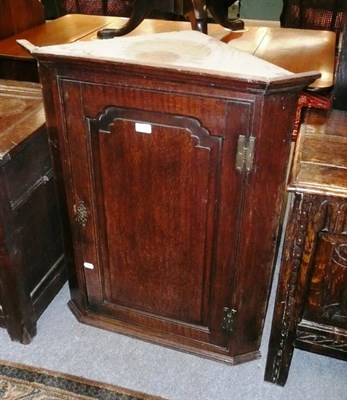 Lot 530 - A George III oak hanging corner cupboard