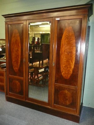 Lot 566 - A late 19th century mahogany triple wardrobe, with central mirror flanked by two panelled doors...