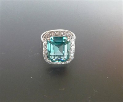 Lot 377 - A Blue Zircon and Diamond Cluster Ring, the emerald-cut blue zircon in a white claw setting...