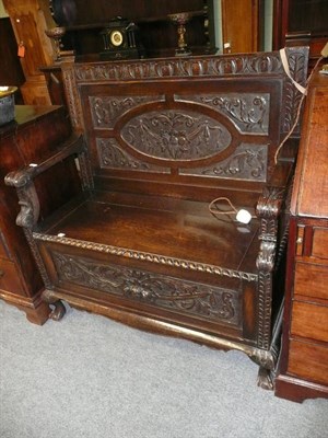 Lot 574 - Carved oak hall bench on claw and ball feet