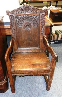 Lot 589 - A 17th century oak wainscot armchair, with panelled back heavily carved with roundels and...