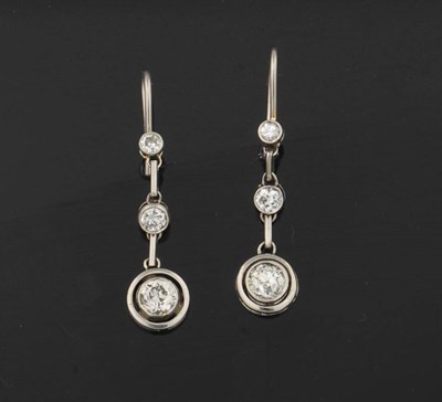 Lot 386 - A Pair of Diamond Drop Earrings, three graduated round cut diamonds in white collet settings,...